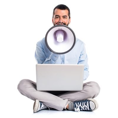 Man with laptop shouting by megaphone